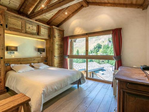 une chambre avec un lit et une grande fenêtre dans l'établissement Cocon raffiné 5 pièces skis aux pieds à Val-d’Isère avec wifi, cheminée et garage - FR-1-694-11, à Val dʼIsère