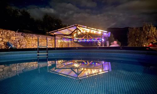 a swimming pool with a lit up building at night at Casale MilleSoli in Mugnano