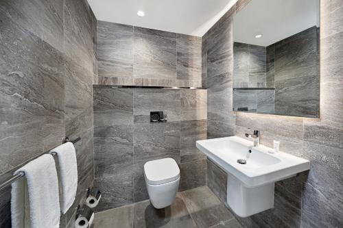 a bathroom with a white sink and a toilet at Holiday Inn Tabuk by IHG in Tabuk