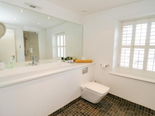 a white bathroom with a toilet and a sink at 14 Llewelyn Street in Conwy