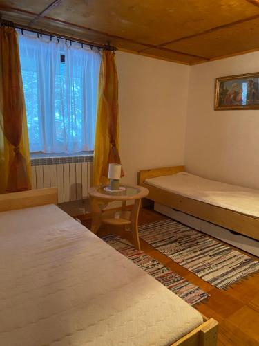 a room with two beds and a table and a window at Hacjenda - domek całoroczny in Krasnobród