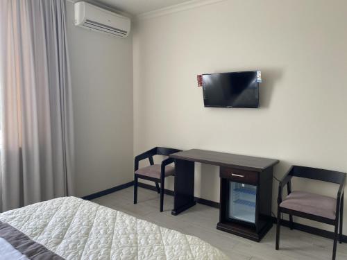 a bedroom with a bed and a desk and a tv at Sun Lidia in Chernivtsi