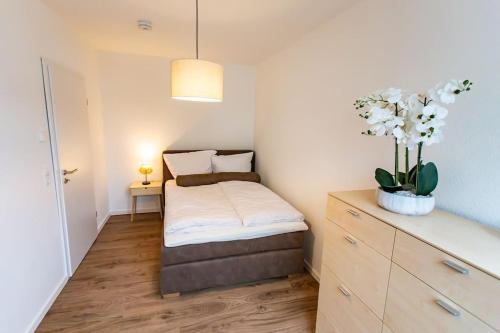 a small bedroom with a bed and a plant at Große COZY 4-Zi-Whg mit Balkon Nähe Europa Park und Rulantica in Lahr