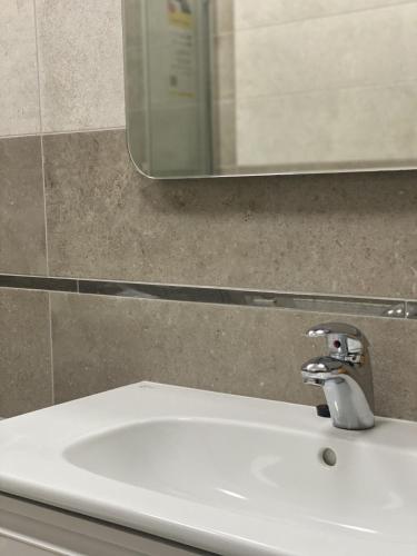a white sink in a bathroom with a mirror at Sun Lidia in Chernivtsi
