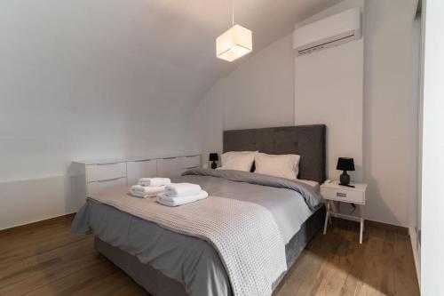 ein Schlafzimmer mit einem Bett mit zwei Handtüchern darauf in der Unterkunft Μεζονέτα με θέα στο πάρκο Σταύρος Νιάρχος ONE in Athen