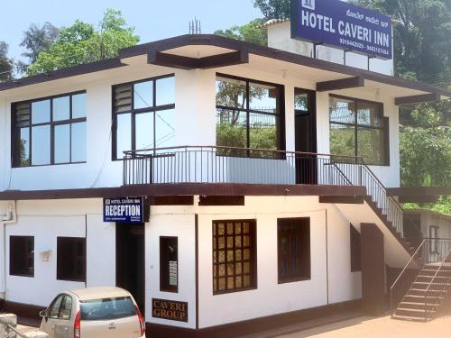 a building with a car parked in front of it at Hotel Caveri Inn in Madikeri