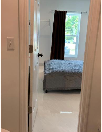 a door to a bedroom with a bed and a window at Boca Raton home in Boca Raton