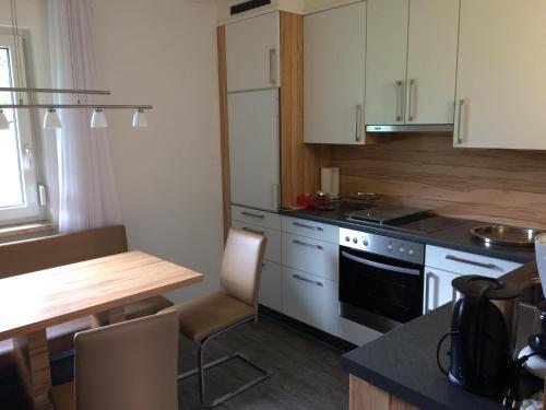 a kitchen with white cabinets and a table and a stove at Haus Berta in Elbigenalp