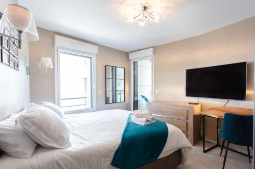 坎城的住宿－C2 Suite Pool Montfleury 2BDR Balcony, Parking & AC，一间卧室配有一张床和一张书桌及电视