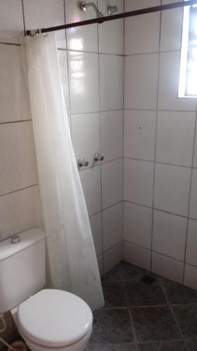 a bathroom with a white toilet and a shower at Diamantina Ecohostel in Diamantina