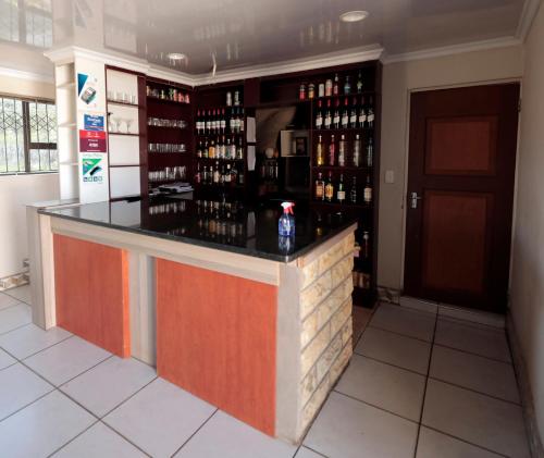 un bar en una habitación con botellas de vino en The Stone Guest House, en Teyateyaneng
