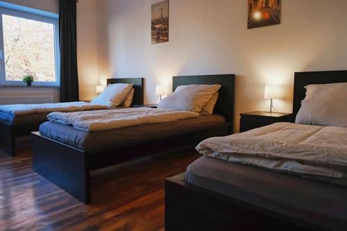 a room with two beds and a window and two lamps at Schöne 4-Bettzimmer Wohnung in Celle in Celle