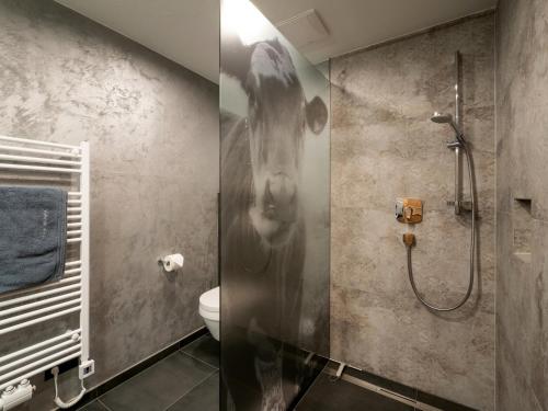 a bathroom with a shower with a cow head on the wall at Bauernhof Vordermühltal in Itter