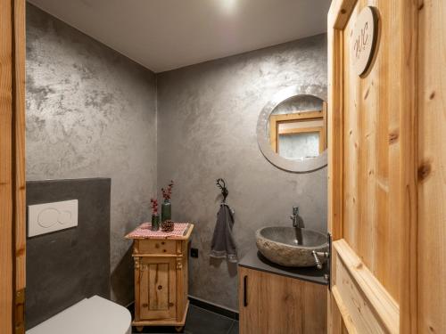 ein Bad mit einem Waschbecken und einem Spiegel in der Unterkunft Bauernhof Vordermühltal in Itter