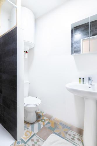 une salle de bain avec des toilettes blanches et un lavabo dans l'établissement Le Beteille, à Rodez