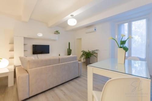 ein Wohnzimmer mit einem Sofa und einem TV in der Unterkunft Un'Oasi di Pace in Ferrara