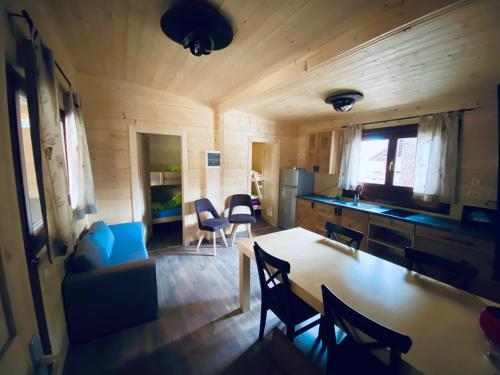 cocina y sala de estar con mesa y sillas en Wooden lodge with jacuzzi, en Rečica ob Savinji
