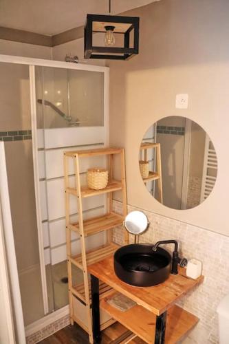 La salle de bains est pourvue d'un miroir et d'une table en bois. dans l'établissement STUDIO EXOTIC - PROCHE GARE - WiFi - NETFLIX, à Amiens
