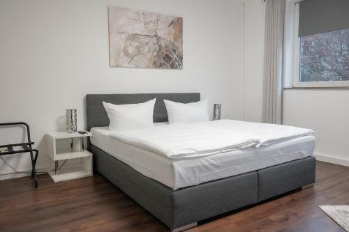 um quarto com uma cama grande e lençóis brancos em Hotel Teatro em Kassel