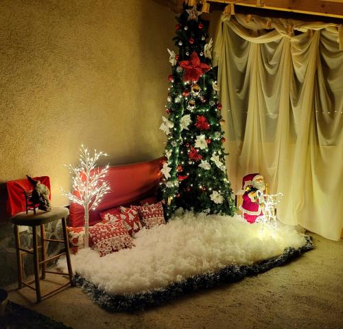a living room with a christmas tree and christmas presents at Dvor in Donja Toponica