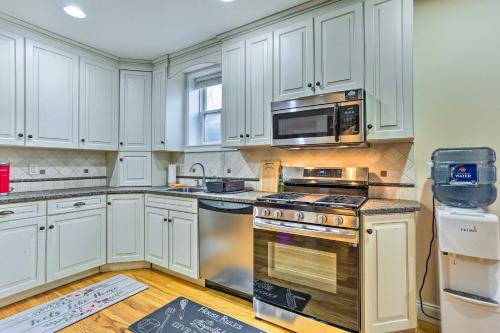 a kitchen with white cabinets and a stove and a microwave at New Jersey Abode - Near the Statue of Liberty in Haskell