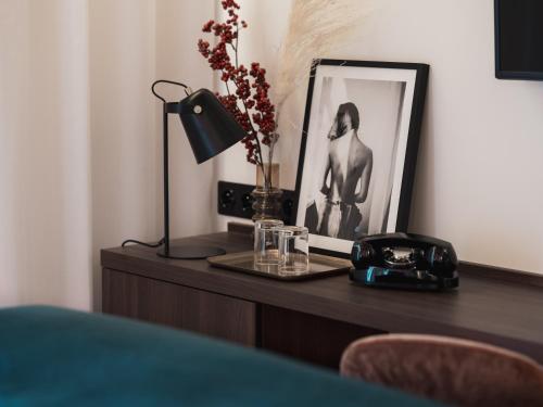 a desk with a picture and a lamp and a phone at Seven Hotel in Paris