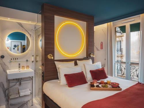 a bedroom with a bed with a sink and a mirror at Seven Hotel Paris in Paris