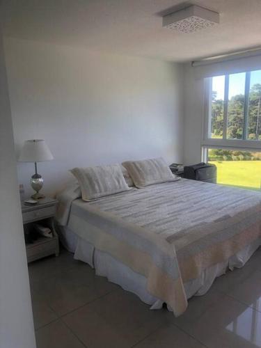 Un dormitorio con una cama grande y una ventana en Inolvidable paz y belleza, en Punta del Este