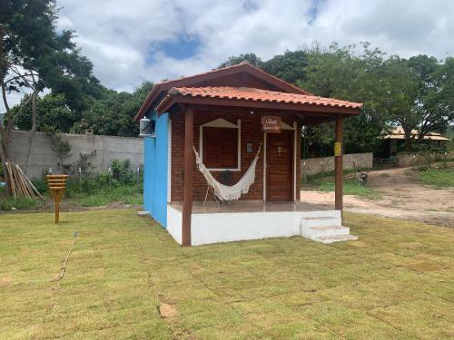 a small shed with a hammock in a yard at Chalé Topázio no Recanto Diamantina entre Palmeiras e Capão in Palmeiras