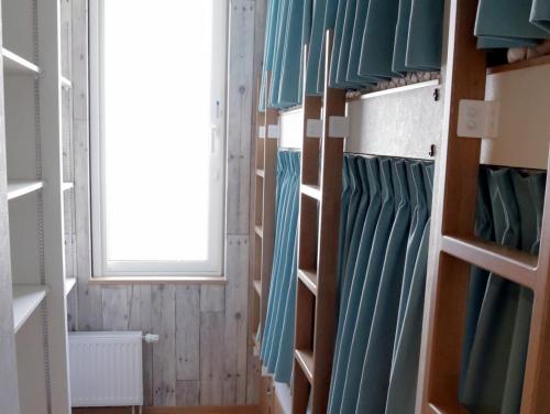 a walk in closet with green cabinets and a window at Ocho Guest House in Sapporo