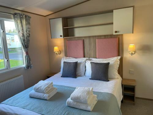 a bedroom with a bed with two towels on it at Rockley Park Private Holiday Homes in Poole