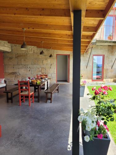 a patio with a table and chairs and a stone wall at Alijó Douro House in Alijó