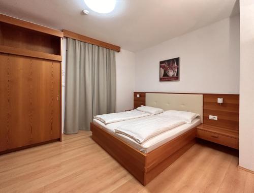 a bedroom with a bed and a closet at Roter Adler in Caldaro