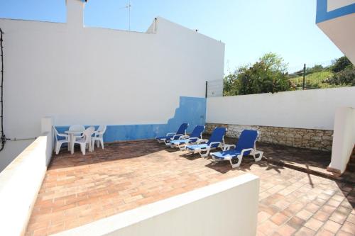 a group of chairs and tables on a patio at T2 Casa dos Arcos by Seewest in Salema