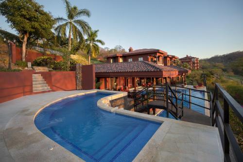 een huis met een zwembad voor een huis bij Bougainvillea 9305 Luxury Apartment - Reserva Conchal in Playa Conchal