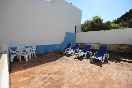 a group of chairs and tables on a brick patio at T2 Casa dos Arcos by Seewest in Salema