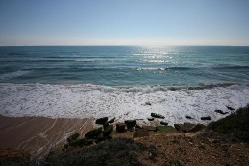 a view of the ocean from a rocky beach at T2 Casa dos Arcos by Seewest in Salema