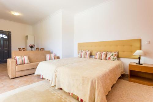 um quarto com uma cama grande e um sofá em Estudios Montinhos Da Luz by Seewest na Praia da Luz