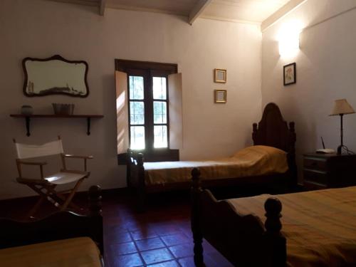 ein Schlafzimmer mit einem Bett, einem Stuhl und einem Fenster in der Unterkunft Casa quinta Santa Ines in Buenos Aires
