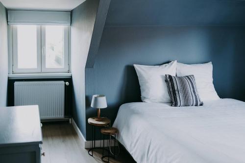 Schlafzimmer mit einem großen weißen Bett und einem Fenster in der Unterkunft Charmeverblijf Juliette in Kasterlee