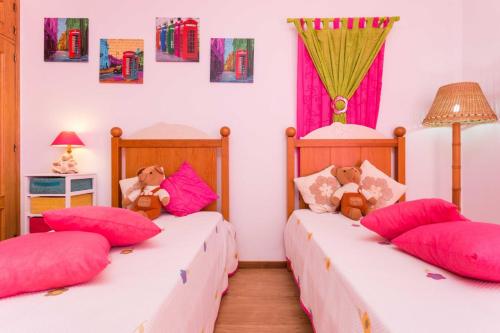 zwei Betten in einem Zimmer mit zwei Teddybären in der Unterkunft Sunflower Villa by Seewest in Porto de Mós