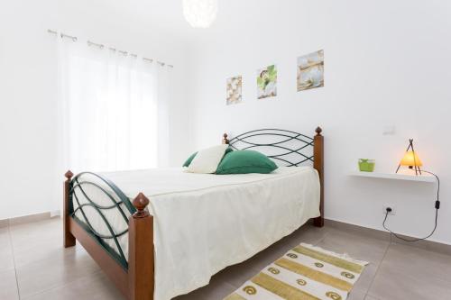 ラゴスにあるCandy Home by Seewestのベッドルーム1室(緑の枕が付いたベッド1台付)