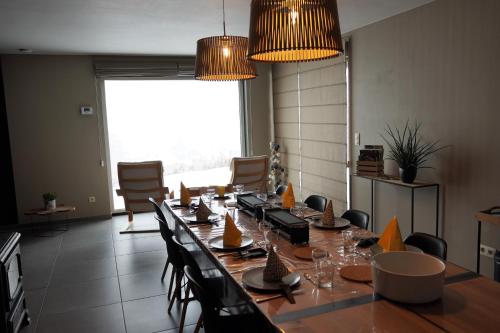 a conference room with a long table and chairs at "Petite perle en Haute Ardenne" avec vue sur la vallée, cabine infra-rouge et bain balnéo in Lierneux