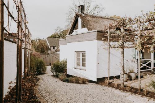 a white house with a gravel driveway in front of it at Charmeverblijf Juliette in Kasterlee