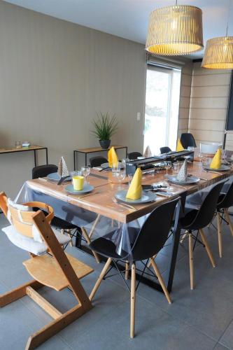 a large wooden table in a room with chairs at "Petite perle en Haute Ardenne" avec vue sur la vallée, cabine infra-rouge et bain balnéo in Lierneux