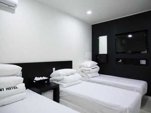 2 camas en una habitación con TV en la pared en Korea guesthouse en Gumi