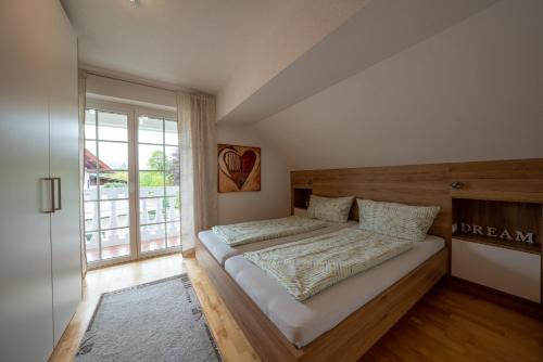 - une chambre avec un lit et une grande fenêtre dans l'établissement Apartment Tinney, à Kössen