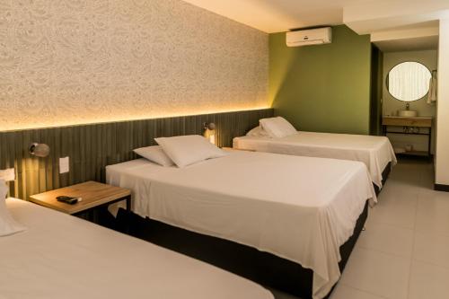 a hotel room with two beds and a table at Hotel Principe in Tuluá