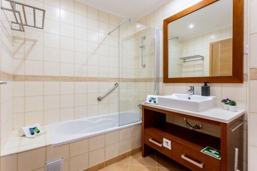 een badkamer met een wastafel, een bad en een spiegel bij Terrace Lovers by Seewest in Lagos