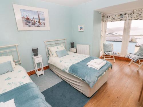 a bedroom with two beds and a window at Gower View in Tenby